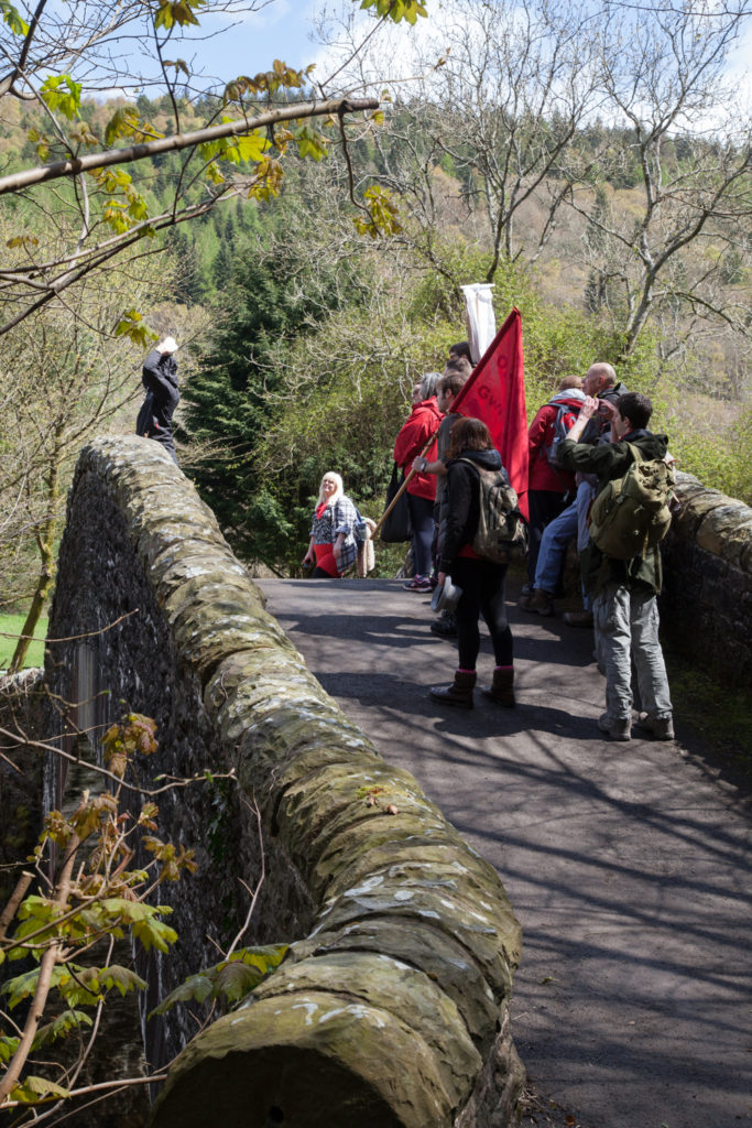 G.B. WALES, Pontygwaith. Walkers arrive at the old works bridge to find performance artist and interventionist Karl Price awaiting their arrival. (2016).